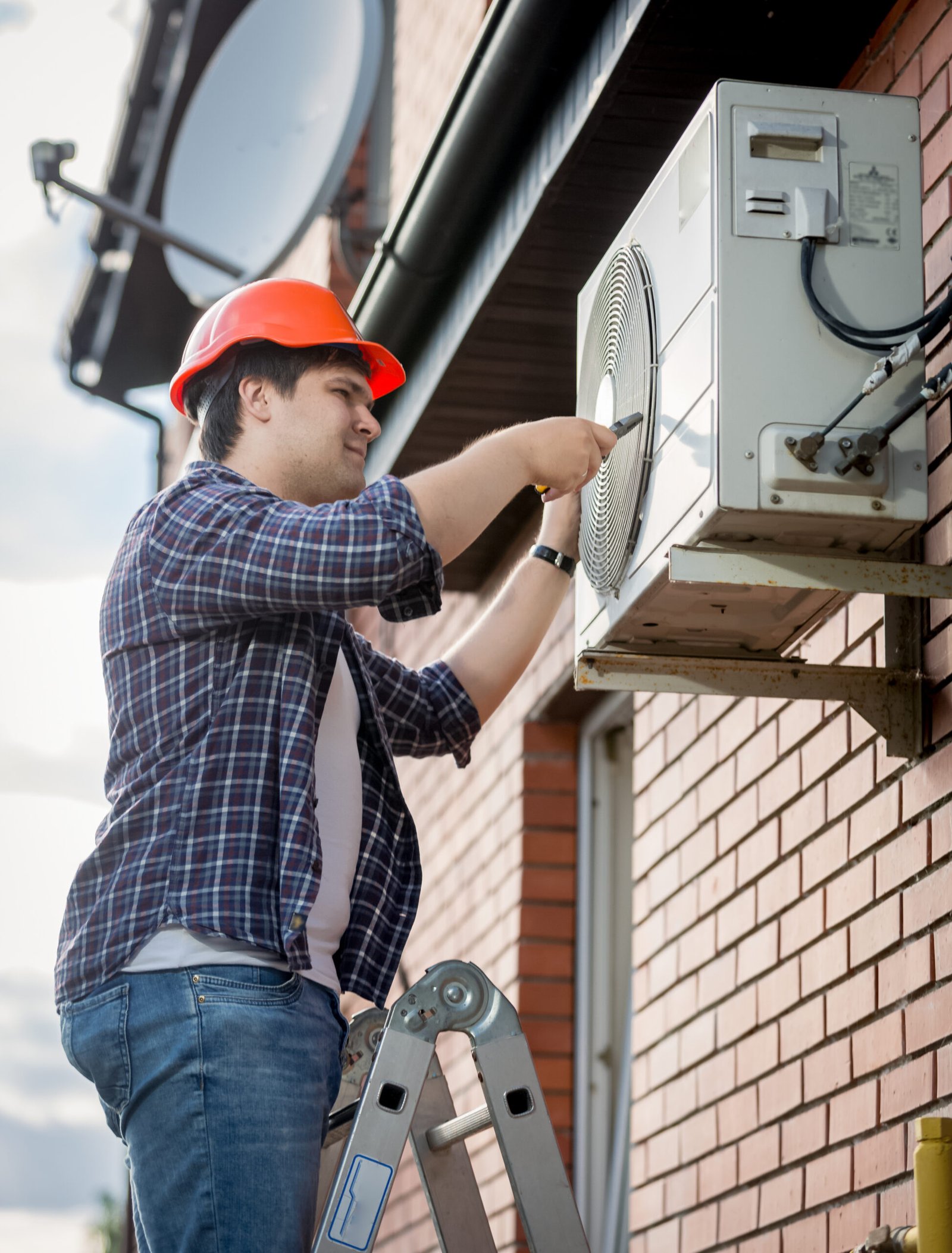 male technician repairing outdoor air conditioning system